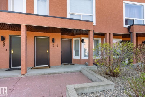 Multi-unit building exterior featuring a textured orange facade and white-framed windows - 108 10105 95 Street, Edmonton, AB - Outdoor With Exterior
