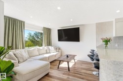 Open-concept living area featuring recessed lighting, wood-finish flooring, and a large window - 