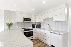 Modern kitchen featuring a U-shaped countertop layout with light-toned surfaces - 