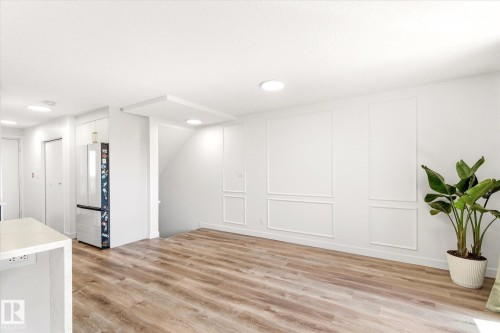 Spacious living area featuring wood-finish flooring, recessed lighting, and decorative wall molding - 108 10105 95 Street, Edmonton, AB - Indoor Photo Showing Other Room