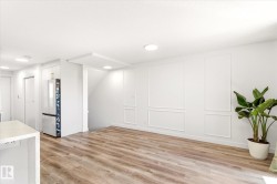 Spacious living area featuring wood-finish flooring, recessed lighting, and decorative wall molding - 