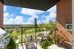 Private balcony featuring a glass railing and a stucco exterior wall - 