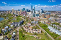 Expansive aerial perspective showcasing a vibrant cityscape with a prominent river and surrounding green spaces - 