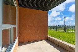 Covered patio space featuring a concrete slab, stucco exterior, and white-framed window - 