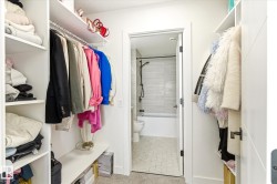 Walk-in closet featuring extensive built-in shelving, hanging rods, and a carpeted floor - 