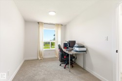 Room featuring a window with exterior scenery, light-colored carpeting, white walls, a ceiling-mounted light fixture, and white baseboards - 