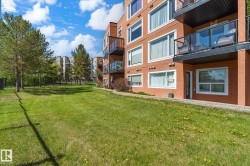 Multi-story building featuring brick-finish siding, multiple balconies with glass railings, and white-framed windows - 