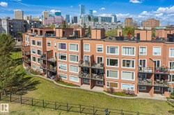 Multi-story residential building featuring a red brick facade with multiple balconies - 