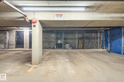 Concrete parking structure featuring a designated parking space with yellow demarcation lines - 