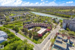 Aerial perspective showcasing a complex of brick residential buildings, surrounded by mature trees and verdant landscapes - 