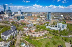 Expansive cityscape featuring diverse architectural styles, a mix of high-rise and mid-rise buildings, extensive green spaces, and established residential areas - 