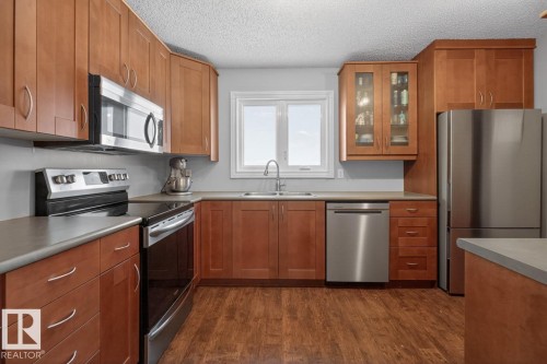 Kitchen featuring Stainless Steel Appliances, Ample Cabinets, Counter Space, and Storage with South Facing Window overlooking your Private Backyard. - 18655 61 Avenue, Edmonton, AB - Indoor Photo Showing Kitchen With Stainless Steel Kitchen With Double Sink