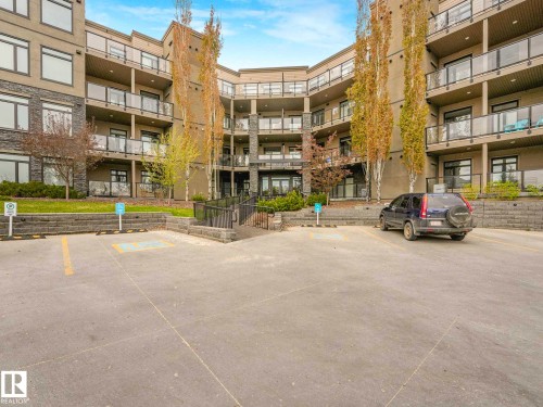 Multi-story condominium building featuring stone and stucco exterior finishes - 213 625 Leger Way, Edmonton, AB - Outdoor With Balcony