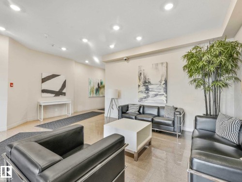 Lobby area featuring polished tile flooring, recessed ceiling lighting, and a white console table - 213 625 Leger Way, Edmonton, AB - Indoor