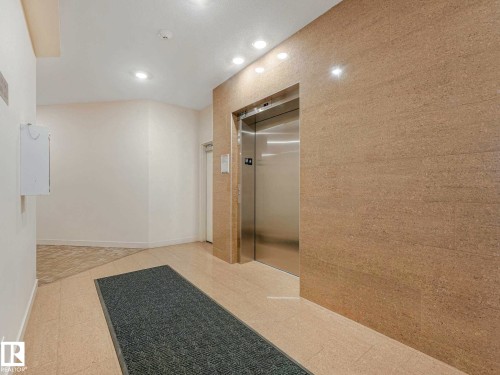 Modern elevator entrance featuring a stainless steel door and a textured wall finish - 213 625 Leger Way, Edmonton, AB - Indoor Photo Showing Other Room