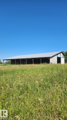 Metal-sided agricultural structure with an extended covered area - 50206 Range Road 215, Rural Leduc County, AB 