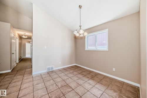 Dining area featuring tile flooring, a multi-pane window, and a chandelier lighting fixture - 9825 156 Street, Edmonton, AB - Indoor Photo Showing Other Room