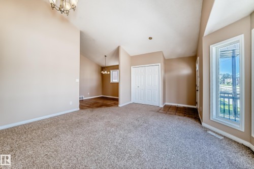 Carpeted living area with vaulted ceilings and neutral wall tones - 9825 156 Street, Edmonton, AB - Indoor Photo Showing Other Room