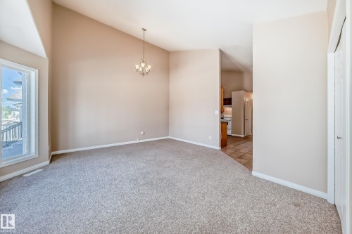 Spacious room featuring vaulted ceilings and neutral-toned carpeting - 9825 156 Street, Edmonton, AB - Indoor Photo Showing Other Room