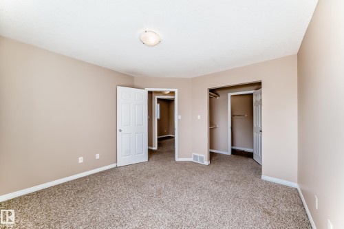 Carpeted room with neutral-toned walls, white trim, and a ceiling-mounted light fixture - 9825 156 Street, Edmonton, AB - Indoor