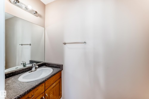 Warm wood cabinetry with chrome hardware - 9825 156 Street, Edmonton, AB - Indoor Photo Showing Bathroom