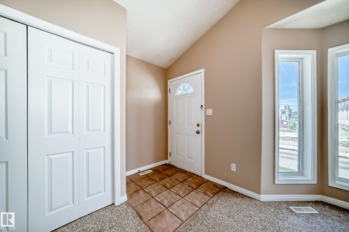 Entryway featuring a vaulted ceiling, durable tile flooring, and a multi-pane front door - 9825 156 Street, Edmonton, AB - Indoor Photo Showing Other Room