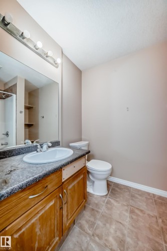 Bathroom with a single vanity, a white oval sink, and a dark speckled countertop - 9825 156 Street, Edmonton, AB - Indoor Photo Showing Bathroom