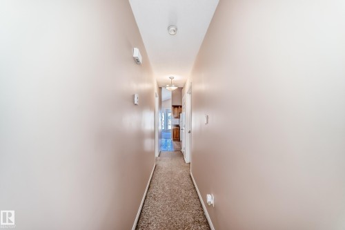 Hallway featuring neutral-toned walls, textured carpeting, and ceiling-mounted lighting fixtures - 9825 156 Street, Edmonton, AB - Indoor Photo Showing Other Room