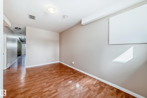 Spacious room featuring wood-finish flooring, light-toned walls, and recessed lighting - 9825 156 Street, Edmonton, AB - Indoor Photo Showing Other Room