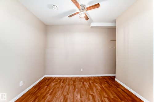 Room featuring wood-finish flooring, a ceiling fan with light fixture, and neutral painted walls - 9825 156 Street, Edmonton, AB - Indoor Photo Showing Other Room