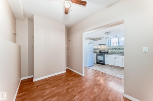 Open-concept living space with wood-finish flooring and a ceiling fan - 9825 156 Street, Edmonton, AB - Indoor