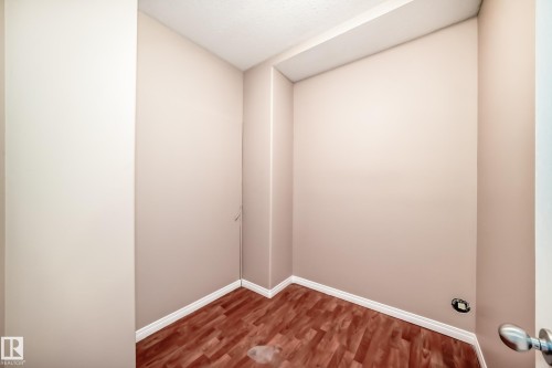 Compact room featuring wood-finish flooring, light-toned walls, and white trim molding - 9825 156 Street, Edmonton, AB - Indoor Photo Showing Other Room