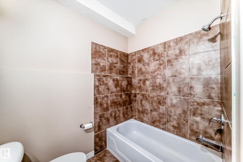 Tub and shower combination featuring brown-toned tile surround - 9825 156 Street, Edmonton, AB - Indoor Photo Showing Bathroom