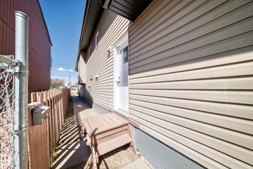 Exterior wall featuring horizontal siding with a white door and wooden steps - 9825 156 Street, Edmonton, AB - Outdoor With Exterior