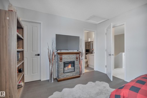18 Southwick Point(E), Leduc, AB - Indoor Photo Showing Bedroom With Fireplace