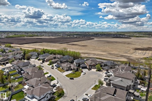 Aerial perspective showcasing a residential development with cul-de-sac streets, individual properties with varied rooflines, private fenced yards, and mature trees - 11024 179 Avenue, Edmonton, AB - Outdoor With View