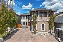 Stucco exterior featuring a double door entry way, stamped concrete driveway, and mature landscaping - 