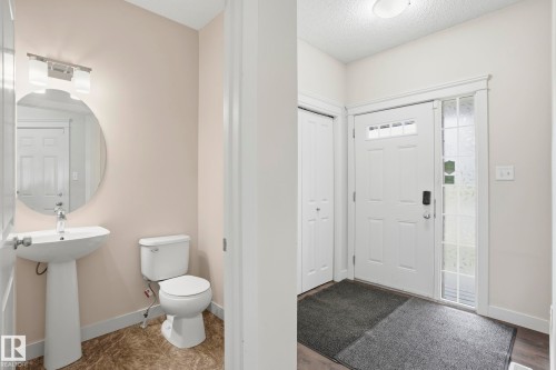 Entryway with a white paneled door featuring decorative glass inserts and an adjacent sidelight - 2917 16A Avenue, Edmonton, AB - Indoor Photo Showing Bathroom