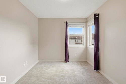 Neutral-toned interior room featuring light gray carpet flooring and white baseboards - 2917 16A Avenue, Edmonton, AB - Indoor Photo Showing Other Room