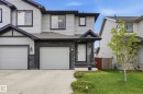 Contemporary exterior featuring light-colored siding with dark trim, a stone accent facade, and a covered front entry - 2917 16A Avenue, Edmonton, AB  - Outdoor 