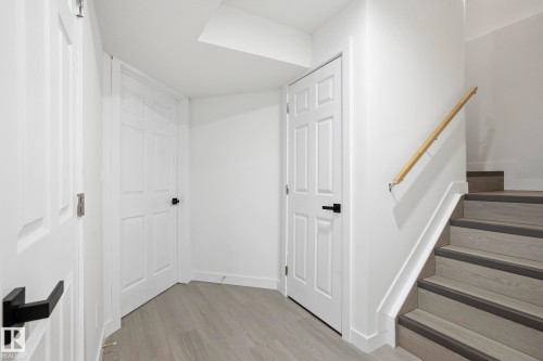 Staircase featuring wood-finish treads with dark risers and a light wood handrail - 2917 16A Avenue, Edmonton, AB - Indoor Photo Showing Other Room