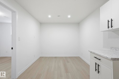 Bright room featuring light wood-finish flooring, white baseboards, and clean white walls - 2917 16A Avenue, Edmonton, AB - Indoor Photo Showing Other Room
