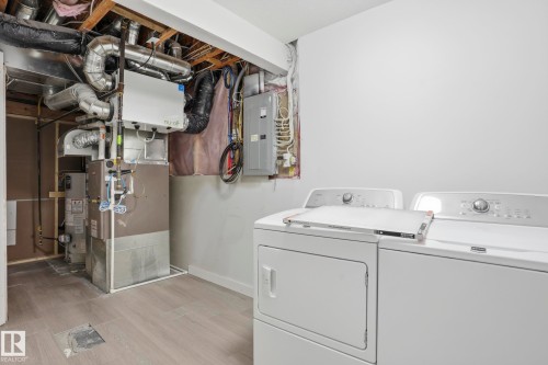 Laundry area featuring light gray wall paint, light wood-finish flooring, and exposed ceiling joists - 2917 16A Avenue, Edmonton, AB - Indoor Photo Showing Laundry Room