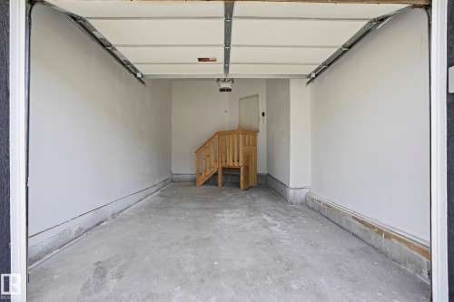 Spacious garage featuring a concrete floor, painted walls, an overhead garage door, and a built-in wooden staircase - 2917 16A Avenue, Edmonton, AB - Indoor Photo Showing Garage