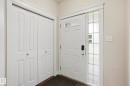 Entryway featuring a paneled door with transom windows, an adjacent sidelight with decorative privacy glass, and a bi-fold closet with panel detailing - 2917 16A Avenue, Edmonton, AB  - Indoor Photo Showing Other Room 