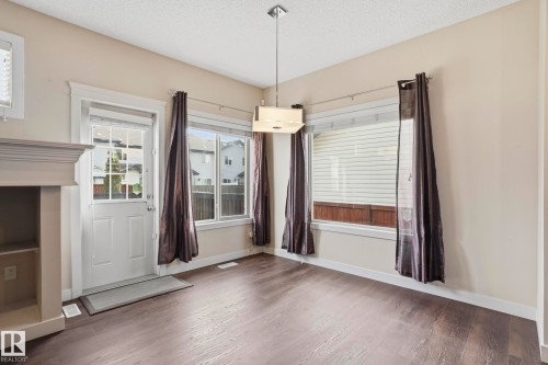 Spacious room featuring wood-finish flooring, light-toned walls, multiple large windows, and a built-in shelving unit - 2917 16A Avenue, Edmonton, AB - Indoor Photo Showing Other Room