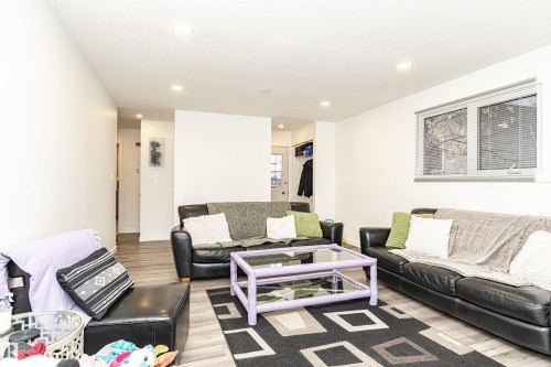 Living area featuring wood-finish flooring, recessed lighting, and a double-pane window - 17716 84 Ave, Edmonton, AB - Indoor Photo Showing Living Room