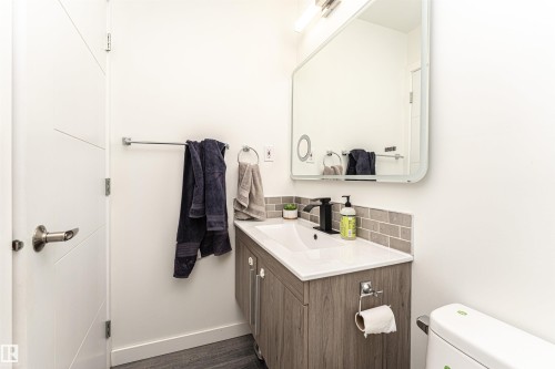 Contemporary vanity featuring a white rectangular sink, matte black faucet, and wood-finish cabinetry - 17716 84 Ave, Edmonton, AB - Indoor Photo Showing Bathroom