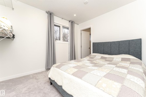 Bedroom featuring light gray carpet flooring, white walls, a single window with gray drapes, and a recessed ceiling light - 17716 84 Ave, Edmonton, AB - Indoor Photo Showing Bedroom