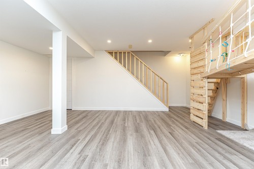 Spacious finished lower level featuring wood-finish flooring, recessed lighting, and a neutral color palette - 17716 84 Ave, Edmonton, AB - Indoor Photo Showing Other Room